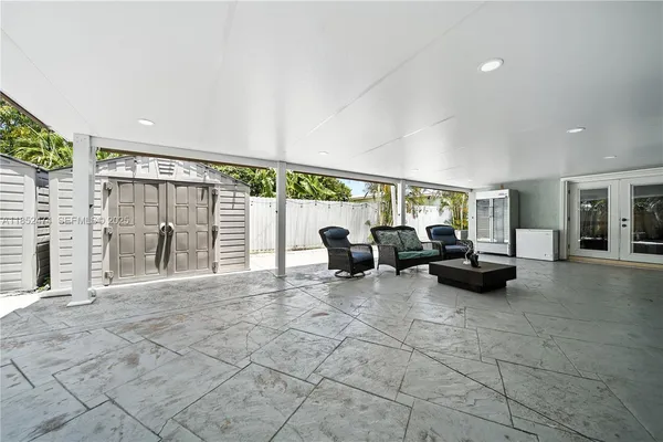 a living room with patio furniture and a garden