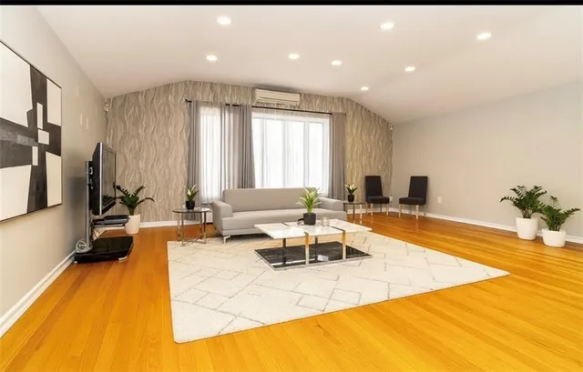 a living room with furniture a rug and a flat screen tv