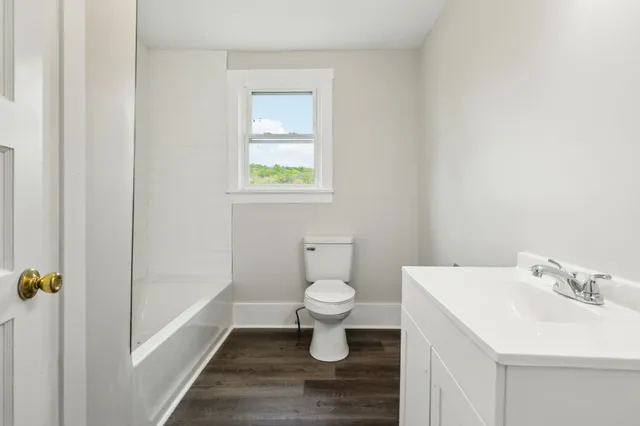 a bathroom with a toilet sink and mirror