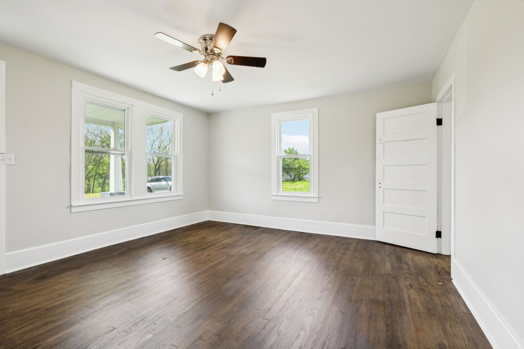 57 Young Branch Road Dixon Springs, TN 37057 - Photo 5 of 24 an empty room with wooden floor chandelier fan and windows