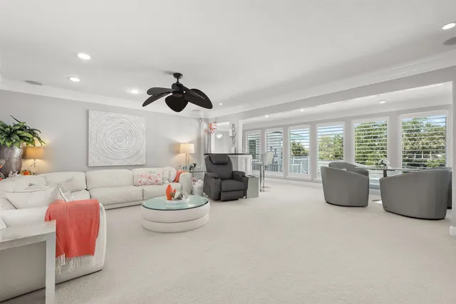 a living room with furniture a flat screen tv and a floor to ceiling window