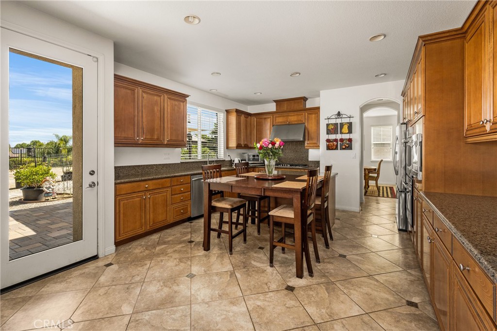 12652 Twin Peak Court Riverside, CA 92503 - Photo 11 of 55 a open dining room with stainless steel appliances a sink a counter top space and a view of kitchen