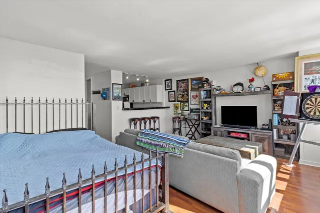 a living room with furniture a flat screen tv and a book shelf