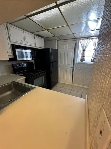 a kitchen with a refrigerator and a stove top oven