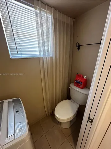 a white toilet sitting next to a small window