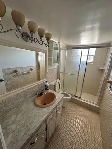 a bathroom with a sink a toilet a mirror and vanity