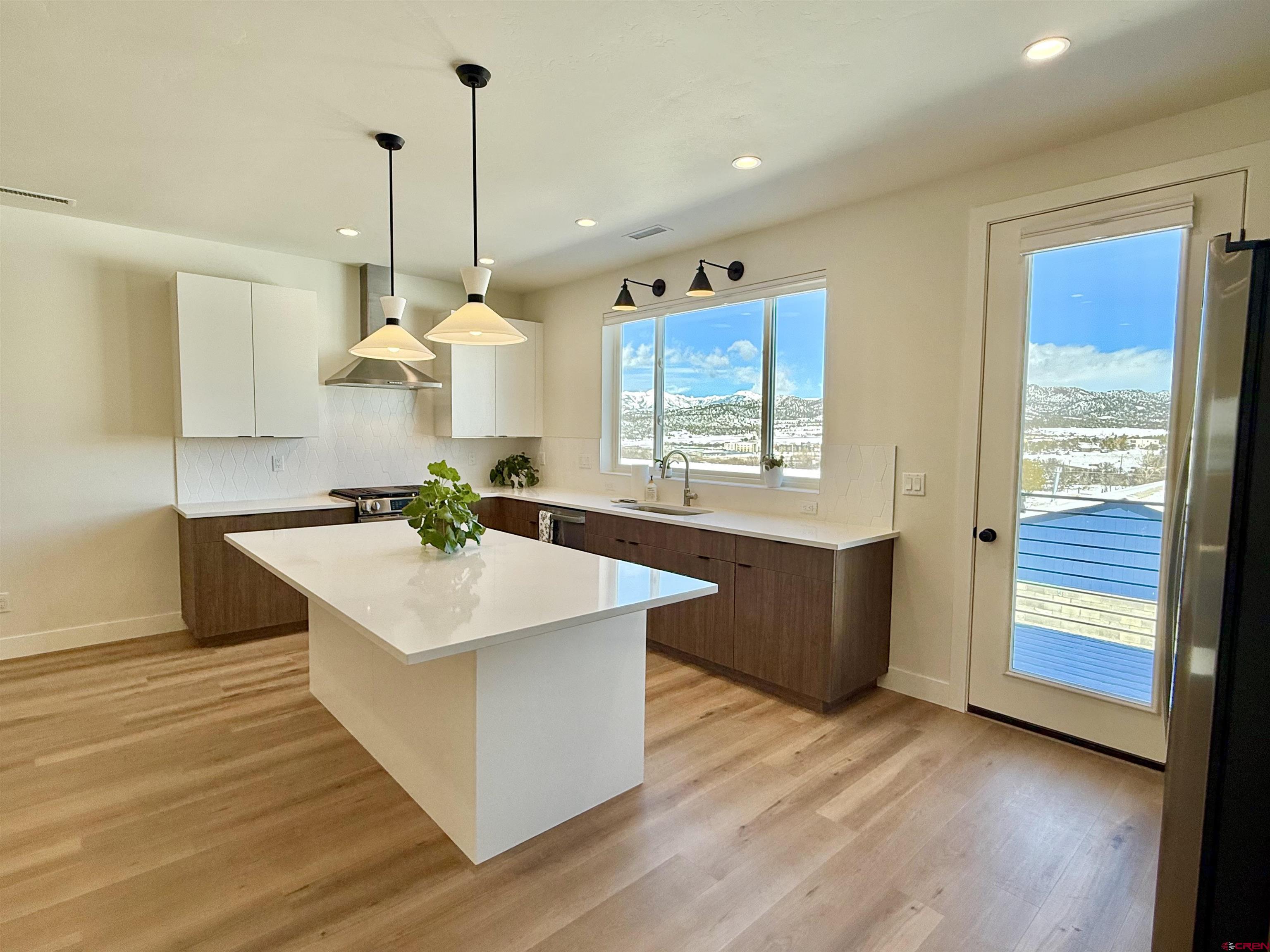 205 Treeline Street Durango, CO 81303 - Photo 11 of 39 a kitchen with stainless steel appliances granite countertop a sink a stove and a wooden floor