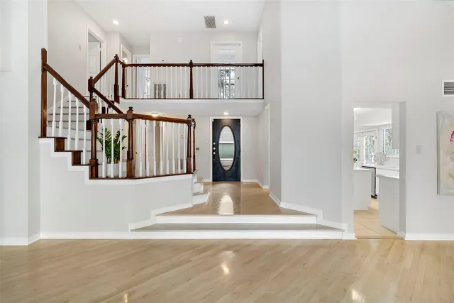 a view of a hallway with wooden floor and staircase