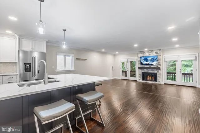 a large kitchen with granite countertop a large center island a sink stainless steel appliances and cabinets