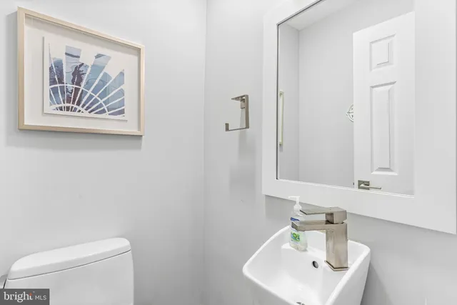 a bathroom with a toilet a sink and mirror