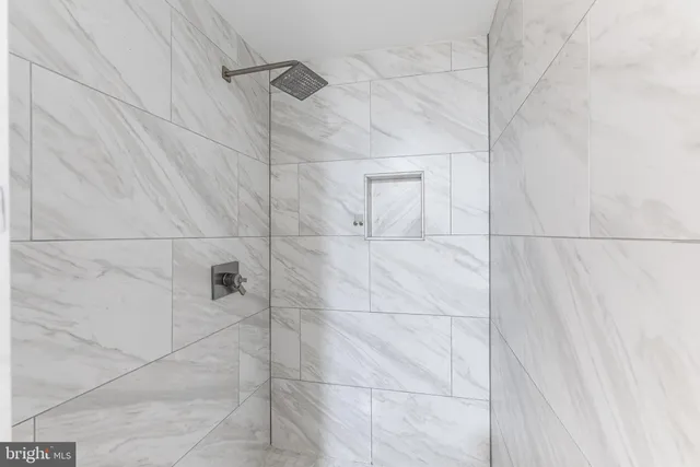 a view of a hallway with wooden floor and a bathroom view