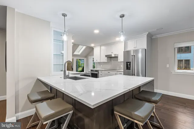 a kitchen with a dining table chairs and refrigerator