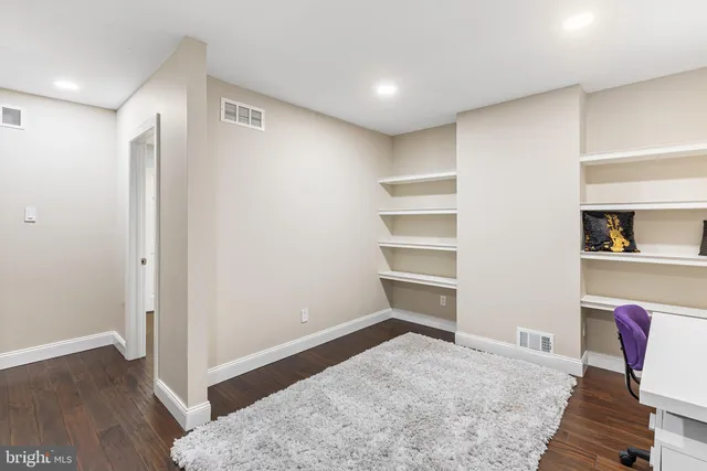 a living room with a desk and chair