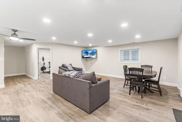 a living room with furniture a wooden floor and kitchen view