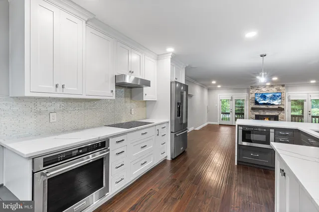 a kitchen with stainless steel appliances kitchen island granite countertop a stove a sink and a refrigerator