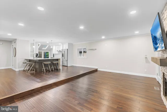 a kitchen with stainless steel appliances a dining table chairs and a wooden floor