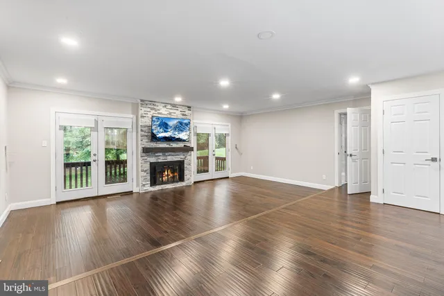 an open space with wooden floor fireplace and windows