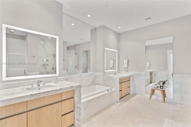 a spacious bathroom with a granite countertop tub sink shower and mirror