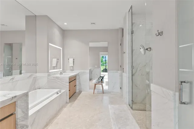 a spacious bathroom with a granite countertop tub sink a mirror a shower and vanity