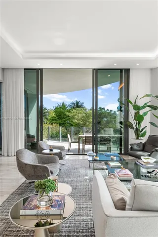 a living room with patio furniture and a potted plant