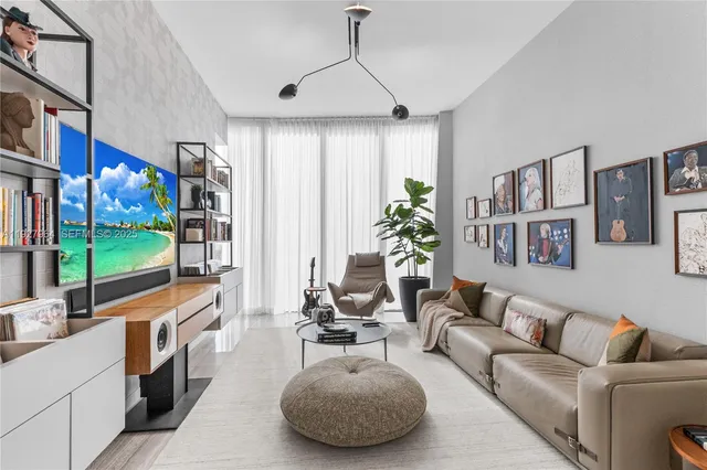 a living room with furniture and a floor to ceiling window