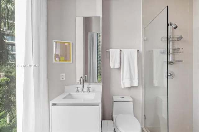 a bathroom with a toilet sink vanity and shower