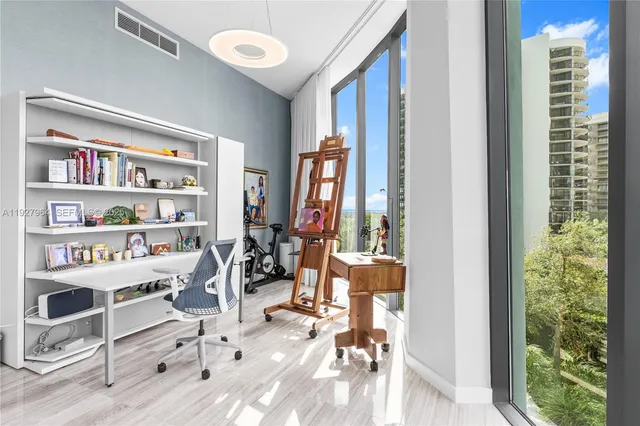 a view of a workspace with furniture and a window