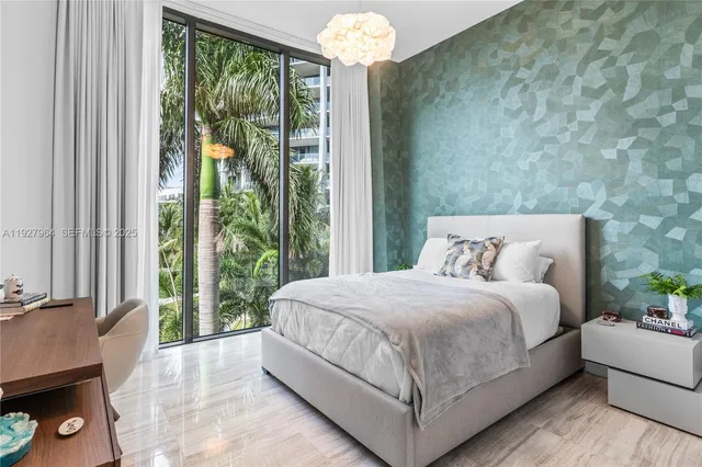 a bedroom with a large bed and a chandelier