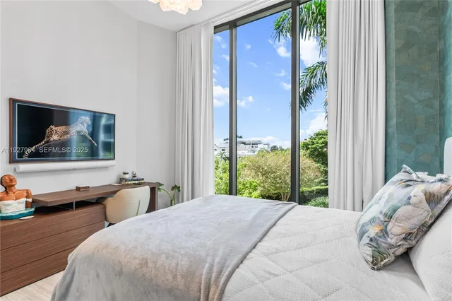 a bedroom with a bed and large windows
