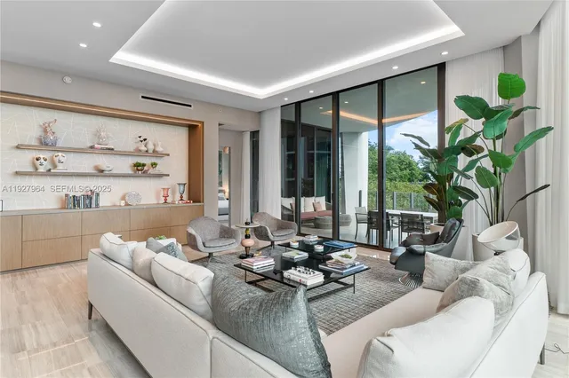 a living room with furniture potted plant and a large window