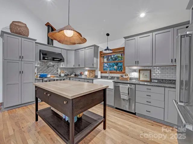 a kitchen with stainless steel appliances granite countertop a sink and a refrigerator