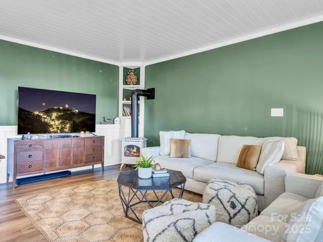 a kitchen with stainless steel appliances granite countertop a refrigerator a stove a sink dishwasher and white cabinets with wooden floor