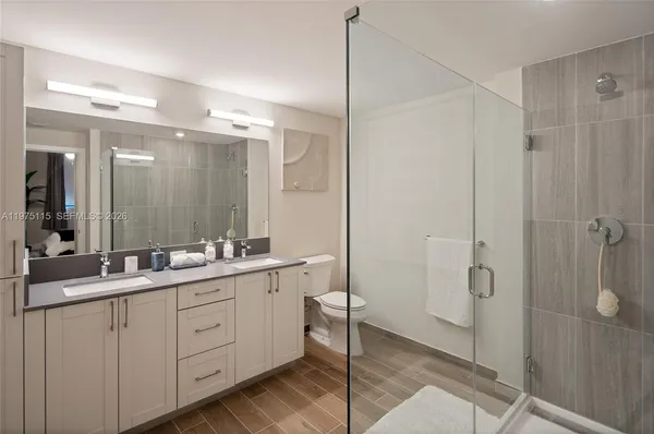 a bathroom with a double vanity sink mirror and shower