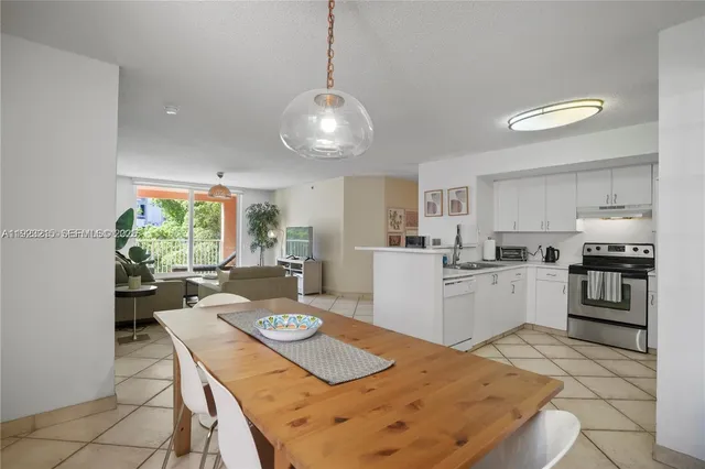 a kitchen with a table chairs stove and refrigerator