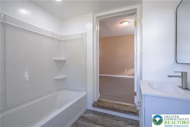 a bathroom with a tub shower and sink