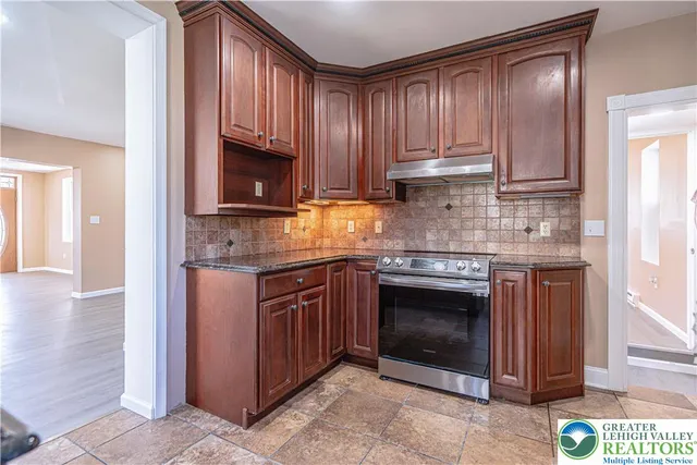 a kitchen with granite countertop stainless steel appliances a stove a sink and a microwave