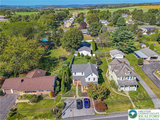 an aerial view of residential houses with outdoor space and street view