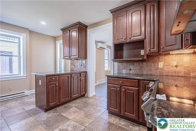 a kitchen with stainless steel appliances granite countertop wooden cabinets a stove top oven a sink and dishwasher
