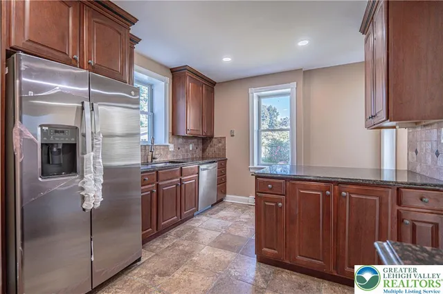 a kitchen with stainless steel appliances granite countertop a refrigerator and a sink