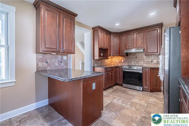 a kitchen with stainless steel appliances granite countertop a stove a sink dishwasher and a refrigerator