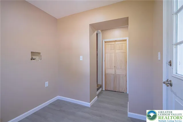 a view of an empty room with wooden floor and closet