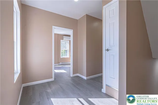 a view of an empty room with wooden floor and closet