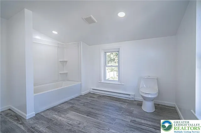 a spacious bathroom with a double vanity sink a mirror and a bathtub