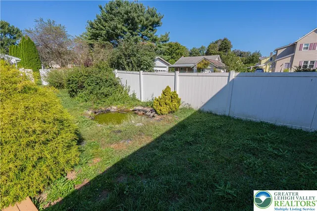 a view of a dry yard with plants and trees
