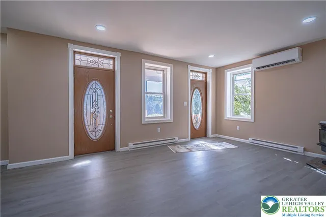 an empty room with wooden floor and window
