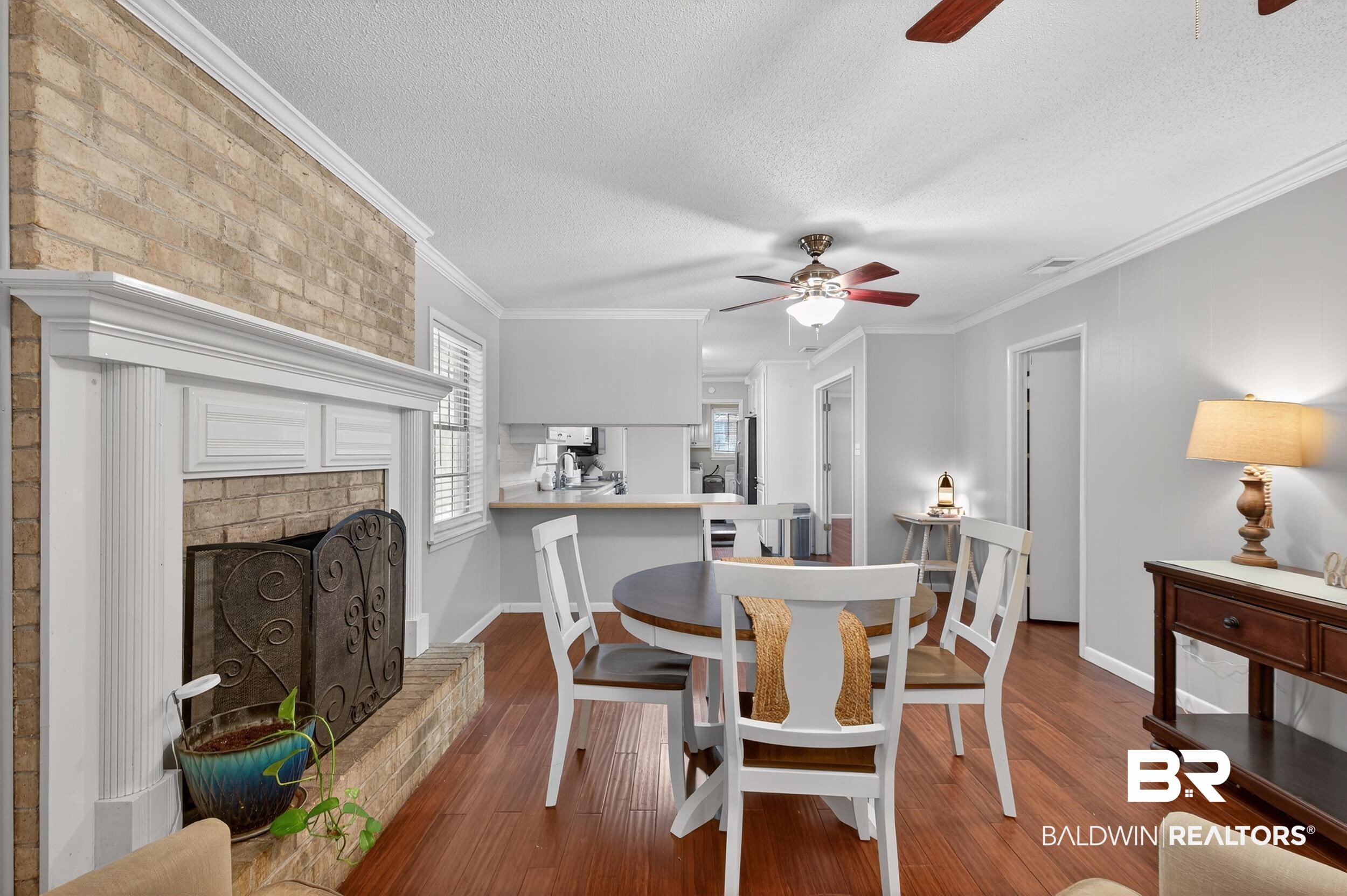 46006 Pecan Lane Bay Minette, AL 36507 - Photo 19 of 40 Dining space with ornamental molding, a fireplace, dark wood-style floors, ceiling fan, and a textured ceiling