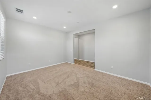 an empty room with windows and closet
