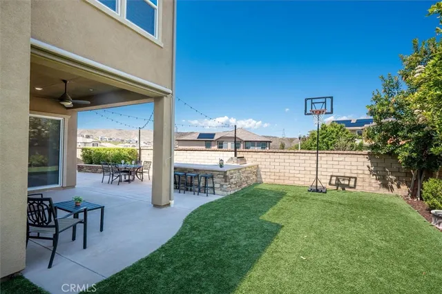 a patio with table and chairs and potted plants