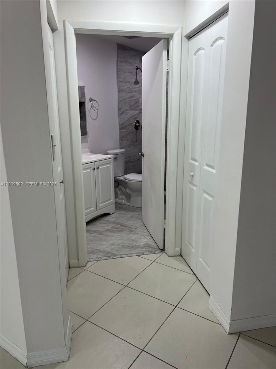 9203 Southwest 138th Place, Unit 9203 Miami, FL 33186 - Photo 16 of 22 a bathroom with a sink a toilet and shower