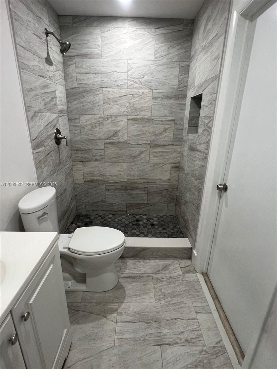 9203 Southwest 138th Place, Unit 9203 Miami, FL 33186 - Photo 19 of 22 a bathroom with a toilet and a shower